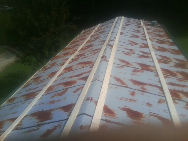 Rusted metal roof panels with new wood purlins before replacement — Storm Damage Roof Repair in Gonzales by Roofing Brothers