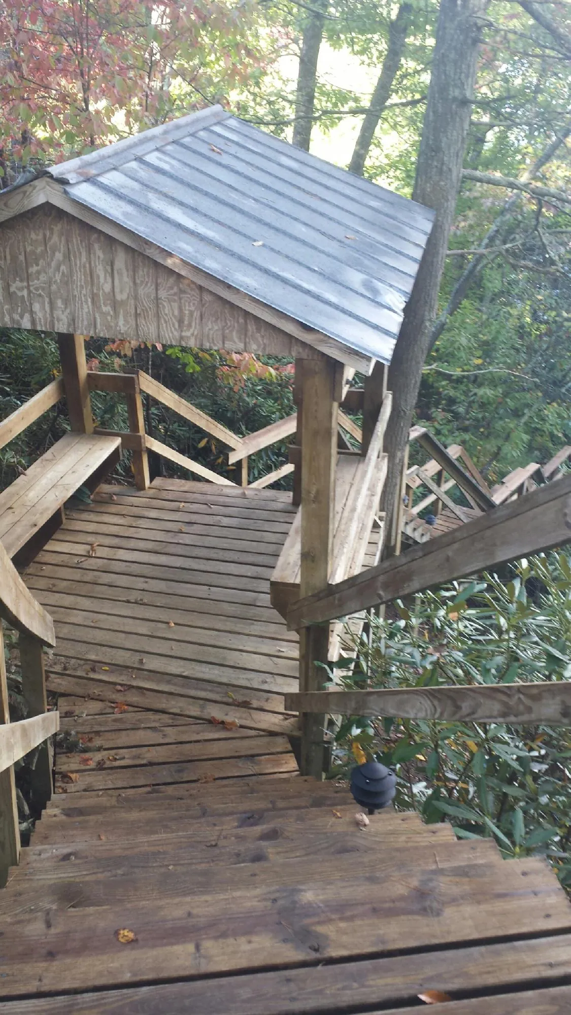 Metal roofed shelter over wooden steps on a wooded walkway — Skylight Repair & Installation work by our crew in Gonzales